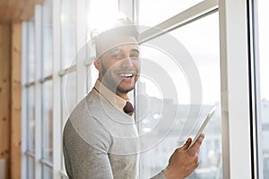 Hispanic Business Man Using Cell Smart Phone Stand in front Panoramic Window Happy Smiling Businessman In Coworking