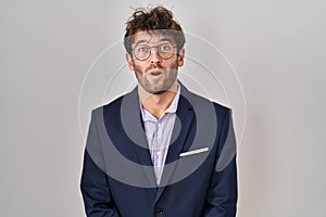 Hispanic business man wearing glasses afraid and shocked with surprise expression, fear and excited face