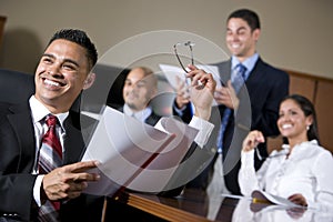 Hispanic business people in boardroom smiling