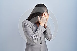 Hispanic business woman wearing glasses with sad expression covering face with hands while crying