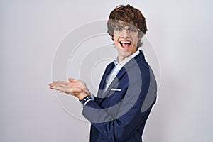 Hispanic business young man wearing glasses pointing aside with hands open palms showing copy space, presenting advertisement