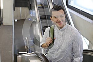 Hispanic businessman using moving staircase