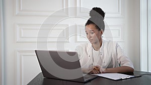 Hispanic businesswoman consultant with laptop talking in white room