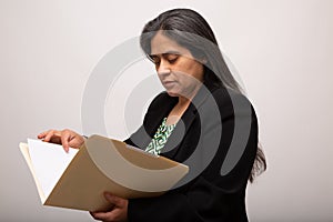 Hispanic Businesswoman Looks Through Folder