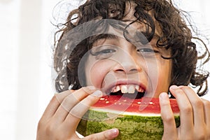 Hispanic child eating fresh watermelon slice