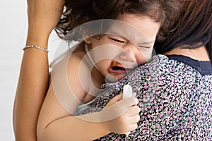 Hispanic children cry when displeased. Parents comfort the crying baby