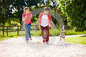 Hispanic Children Taking Dog For Walk