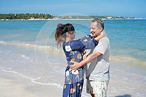 Hispanic couple calm and relax hugging each other standing at the beach during summer