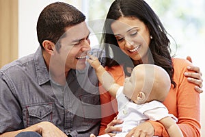 Hispanic couple at home with baby photo