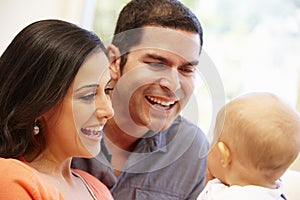 Hispanic couple at home with baby