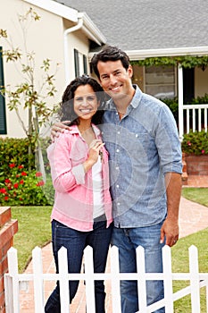 Hispanic couple outside new home