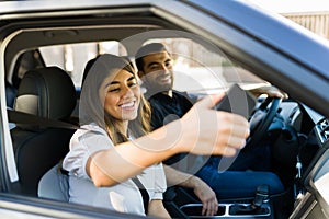 Hispanic couple showing off their new car