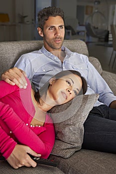 Hispanic Couple On Sofa Watching TV