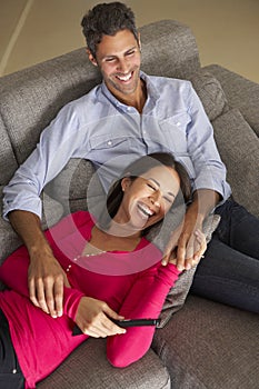 Hispanic Couple On Sofa Watching TV