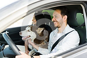 Hispanic couple traveling by car with their dog