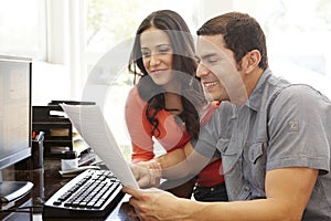 Hispanic couple working in home office