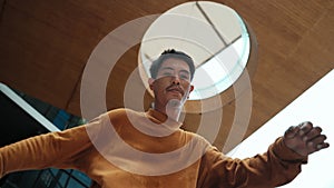 Hispanic dancer looking at camera while dancing at sky scrapper. Endeavor.