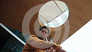 Hispanic dancer looking at camera while dancing at sky scrapper. Endeavor.