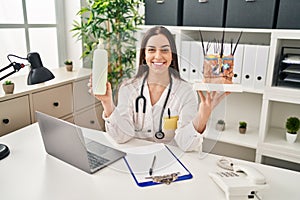 Hispanic doctor woman holding model of human anatomical skin and hair smiling with a happy and cool smile on face photo