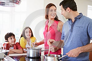 Hispanic Family Cooking Meal At Home