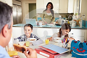 Hispanic Family Eating Breakfast At Home Before School