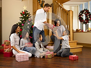 Hispanic family exchanging gifts at Christmas