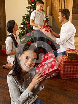 Hispanic family exchanging gifts at Christmas