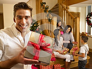 Hispanic family exchanging gifts at Christmas