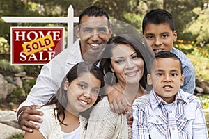 Hispanic Family in Front of Sold Real Estate Sign