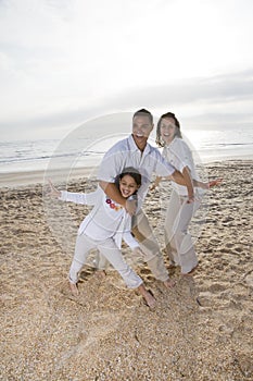 Hispanic family with girl having fun on beach