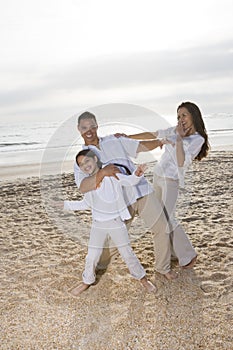 Hispanic family with girl having fun on beach