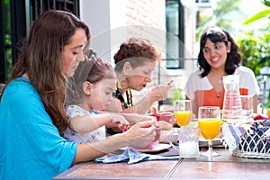 Hispanic family with a girl toddler having breakfast together