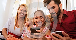 Hispanic Family Laughing Playing Game On Smartphone Telephone