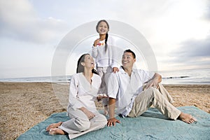 Hispanic family sitting on blanket at beach