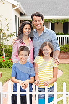 Hispanic family standing outside home photo