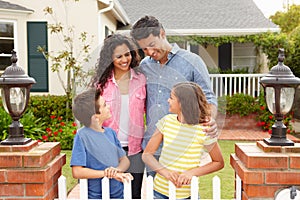 Hispanic family standing outside home