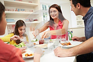 Hispanic Family At Table Eating Meal Together