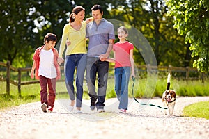 Hispanic Family Taking Dog For Walk