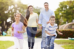 Hispanic Family Walking In Park Together