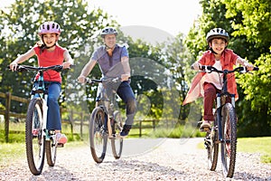 Hispanic Father And Children On Cycle Ride