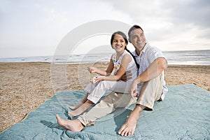 Hispanic father and daughter having fun at beach