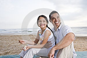 Hispanic father and daughter having fun at beach