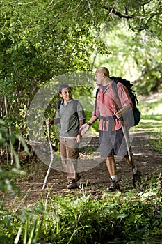 Hispano a un hijo turismo sobre el acera en bosque 