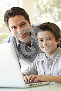 Hispanic Father And Son Using Laptop