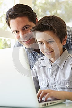 Hispanic Father And Son Using Laptop