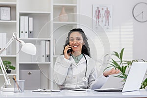 Hispanic female doctor consulting on phone in modern office