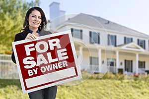 Hispanic Female Holding Sale By Owner Sign In Front of House