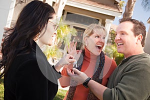 Hispanic Female Real Estate Agent Handing Keys to