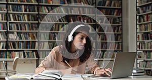 Hispanic female student in headset prepare coursework using books laptop