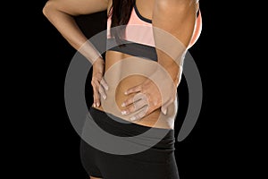 Hispanic fitness woman touching and grabbing her lower back suffering back pain